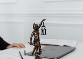 Close-up of Lady Justice statue on a white table in an office setting.